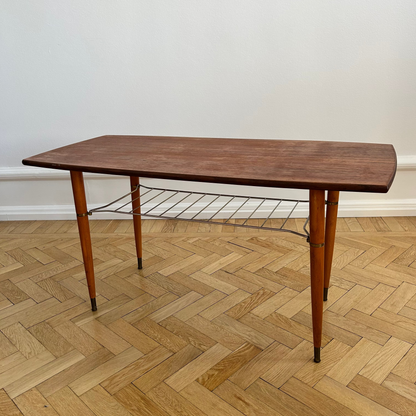 Wooden table on a herringbone parquet floor with a white wall background